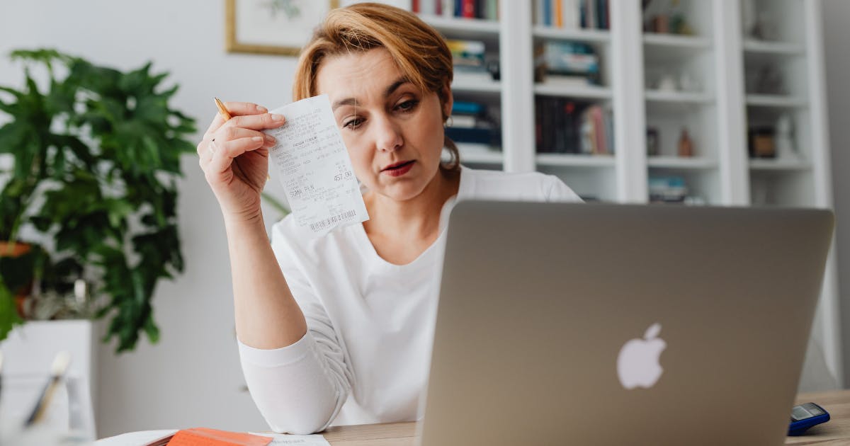 A stressed person surrounded by receipts, highlighting the frustration of managing Software subscriptions manually.