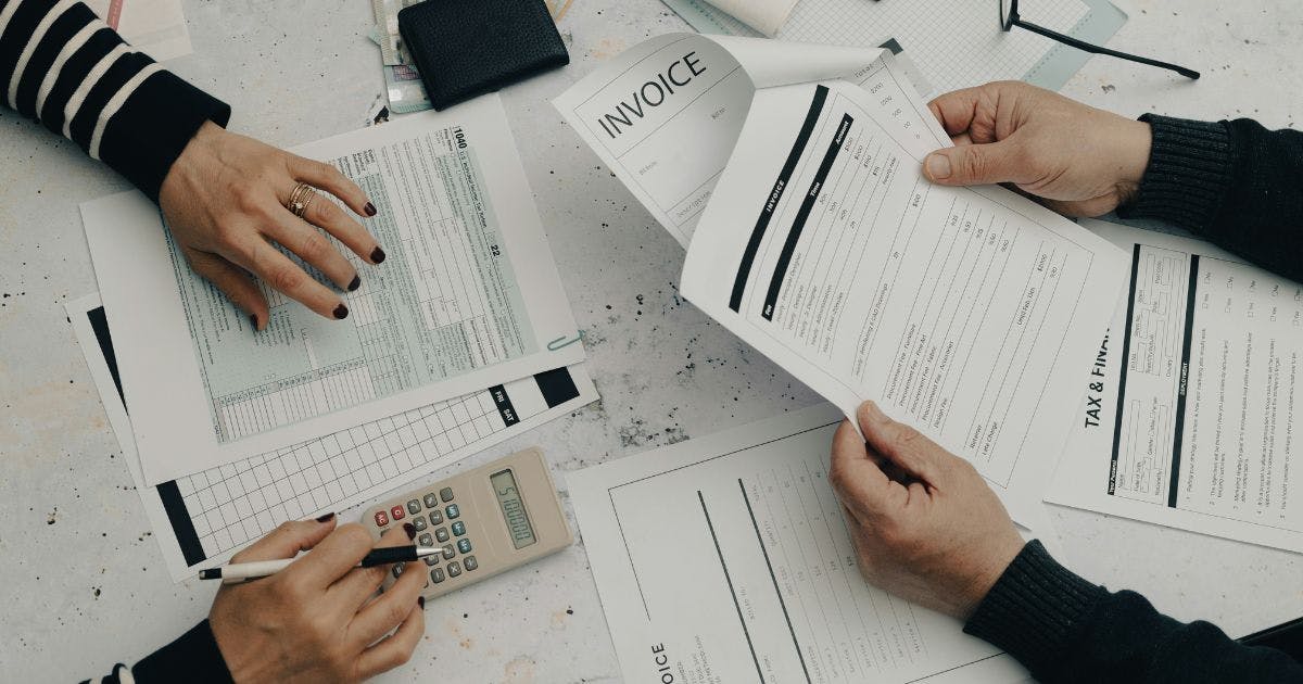 Hands holding invoices and bills, highlighting how spend management simplifies expense tracking.