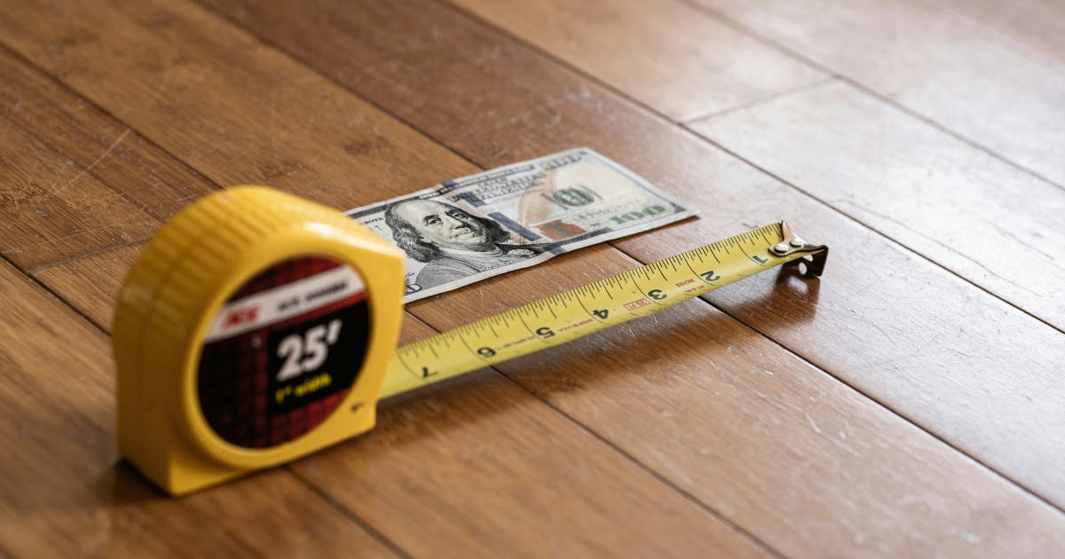 A dollar bill being measured, symbolizing the control gained through tail end management.