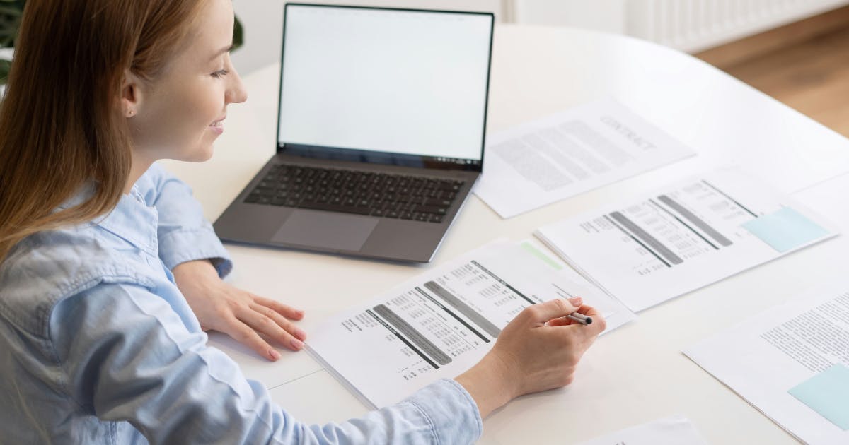 A person overwhelmed by numerous invoices, illustrating the challenges of tracking Saas Spend Management without a dedicated tool.