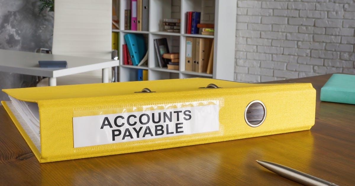 Binder labeled 'Accounts Payable' representing the accounts payable definition and financial records management.